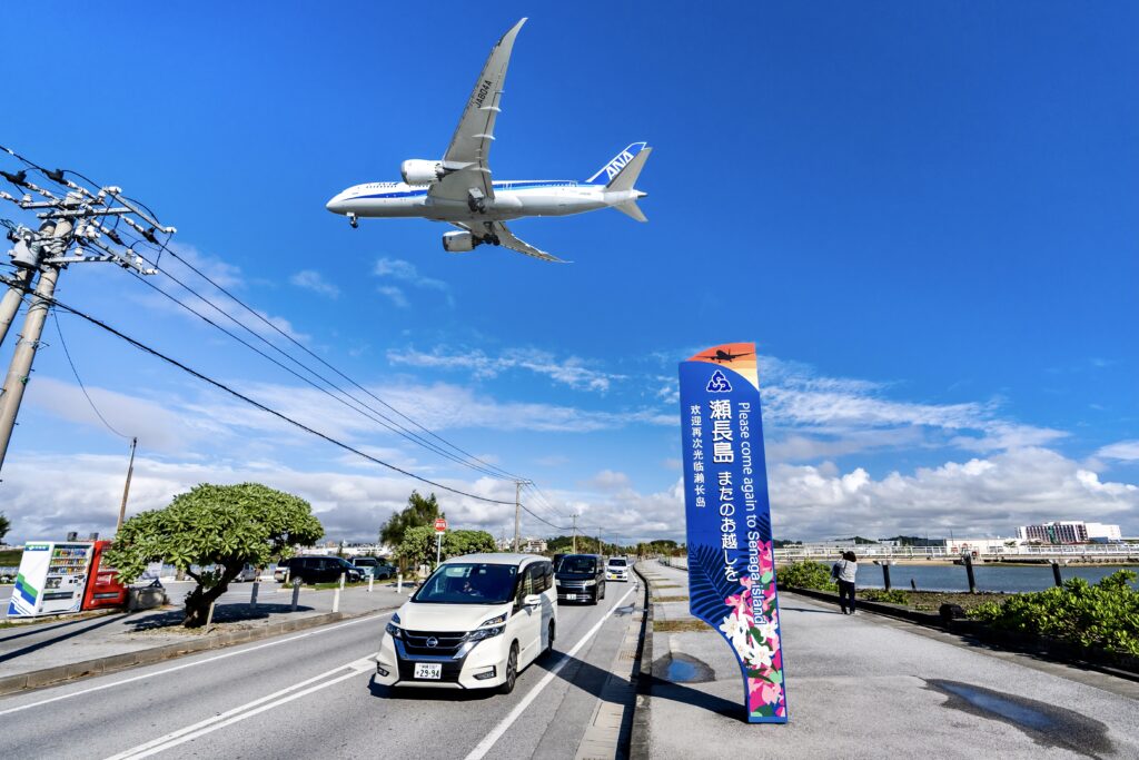 頭上をかすめるように飛ぶ飛行機が見える瀬長島海中道路